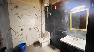 a bathroom with a sink and a toilet at Lotus Lake View Inn in Bhīm Tāl +16 photos