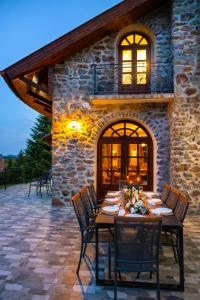 a table and chairs on a patio in front of a building at Jákób-Vár Vendégház in Füzér
