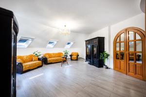 a living room with couches and a chandelier at Jákób-Vár Vendégház in Füzér