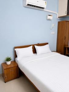 a bedroom with a bed with a white bedsheet at The grand chateau in Singapperumālkovil