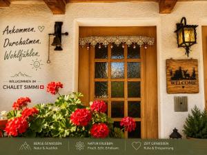 a window of a building with red flowers in front of it at Chalet-Simmi in Wimmis