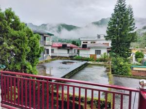 a view from a balcony of a house with a pond at Lotus Lake View Inn in Bhīm Tāl