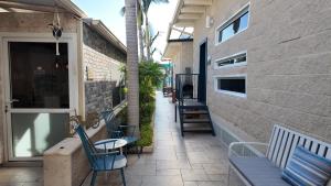 a group of chairs sitting on a patio with a building at אחוזת מיא - סוויטות בוטיק על המים in Goren