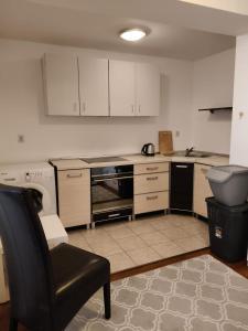 a kitchen with a chair and a stove top oven at Apartament ANTONIA in Olesno