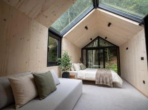 a bedroom with a bed and a couch in a room with windows at Mountain Retreat by Dukley in Kolašin