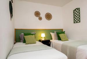 a bedroom with two beds with white and green pillows at VILA NATURA in Barreiro +79 photos