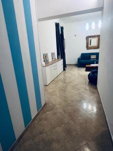 a living room with a blue and white striped wall at Sicilia Vacation rooms in Trapani