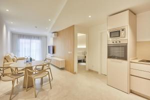 a kitchen and a living room with a table and chairs at Silken Atlantis Playa - Holiday Homes in Las Palmas de Gran Canaria
