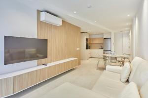 a living room with a large flat screen tv on a wall at Silken Atlantis Playa - Holiday Homes in Las Palmas de Gran Canaria