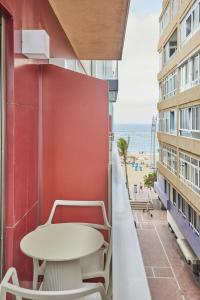 a table and chairs on a balcony with a view of the beach at Silken Atlantis Playa - Holiday Homes in Las Palmas de Gran Canaria