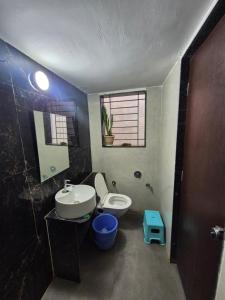 a bathroom with a sink and a toilet and a window at Todkars Villa in Kolhapur +36 photos
