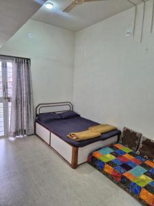 a bedroom with two beds and a window at Todkars Villa in Kolhapur
