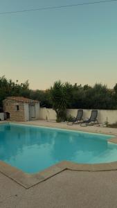 a large blue swimming pool with two chairs around it at Azure Pool Villa in Marseille
