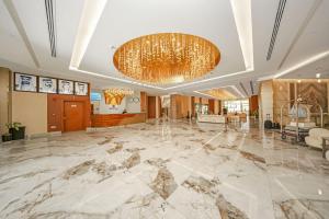 a lobby with a large marble floor and a chandelier at Premium Four Star Hotel by Blue Collection in Ras al Khaimah +74 photos