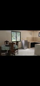 a kitchen with a table and a refrigerator at Melinda Place in Camarin