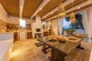 a large kitchen with a wooden table with food on it at Villa Trulli del Gelso in Carovigno
