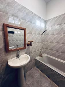 a bathroom with a sink and a mirror and a tub at Cheff Hotel Vianuel in Kendwa +17 photos