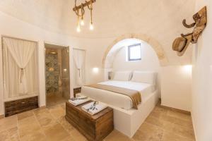 a bedroom with a bed and a walk in shower at Villa Trulli del Gelso in Carovigno +23 photos