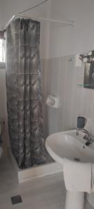 a bathroom with a sink and a shower curtain at Ariadni Fountas Studios in Parga +30 photos