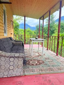 a couch sitting on a porch with a table at Otto's House in Ambrolauri