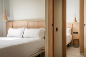 a bedroom with a bed with white pillows at Apartamentos Estival Park in La Pineda +53 photos