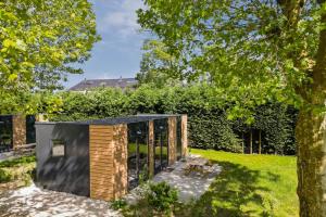 a small house with a black roof at Cube I stijlvol en licht 4 persoons chalet in Zennewijnen