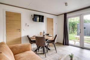 a living room with a table and a couch at Cube I stijlvol en licht 4 persoons chalet in Zennewijnen