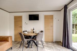 a dining room with a table and chairs at Cube I stijlvol en licht 4 persoons chalet in Zennewijnen