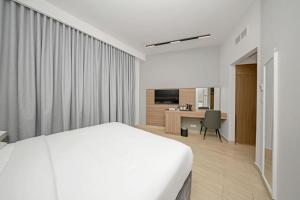 a hotel room with a bed and a desk at Premium Four Star Hotel by Blue Collection in Ras al Khaimah