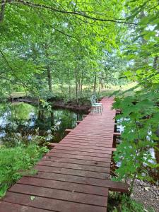 a wooden bridge over a river with two chairs on it at Ferienwohnung Käthe in Filipstad