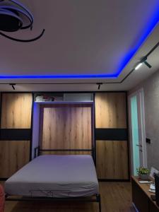 a bedroom with a bed with a blue light on the ceiling at Ines Apartment in Sarajevo