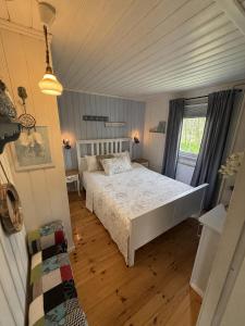 a bedroom with a white bed and a window at Hjartarstaðir Private Country Retreat with Hot Tub in Hagi