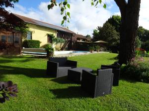 a yard with chairs sitting in the grass at GITE Au Moulié in Blousson-Sérian