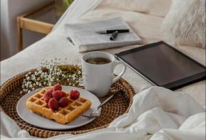 ein Teller Waffeln mit Erdbeeren und eine Tasse Kaffee in der Unterkunft Tejaji हाउसिंग in Jodhpur