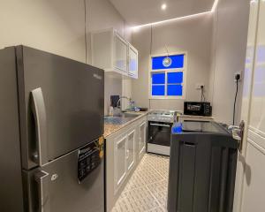 a kitchen with a stainless steel refrigerator and a sink at أجنحة كتارا صلالة Katara Suites Salalah in Salalah