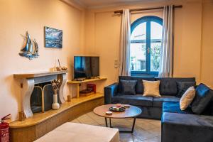 a living room with a blue couch and a fireplace at Myrovolos Guesthouse in Apolpaina
