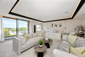 a living room with white furniture and a large window at Designer Haus - Pool - Sea Views - 7BR - Sleeps 14 in Brighton & Hove