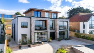 an image of a house with glass windows at Designer Haus - Pool - Sea Views - 7BR - Sleeps 14 in Brighton & Hove +67 photos