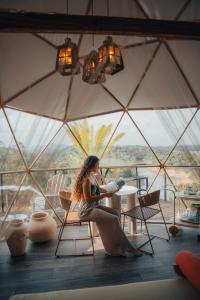 a woman sitting in a chair in front of a large window at Bosko in Guatapé