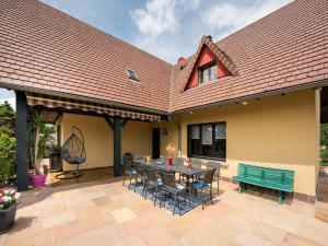a patio with a table and chairs and a bench at Le Cheval Blanc in Ruederbach