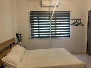 a bedroom with a bed and a window with blinds at The Square Point in Komotini