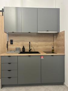 a kitchen with white cabinets and a sink at The Square Point in Komotini