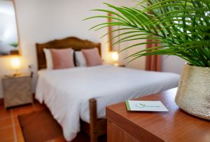 a bedroom with a bed and a plant on a table at VILA NATURA in Barreiro