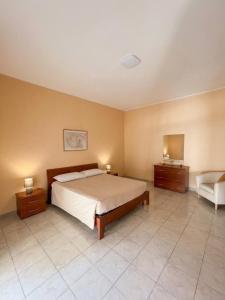 a bedroom with a bed and a couch and a chair at Appartamento Mina' in Adrano +18 photos