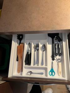a drawer filled with cooking utensils on a shelf at Appartamento Mina' in Adrano