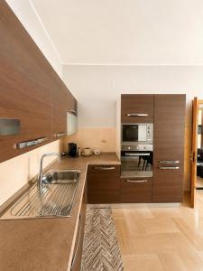 a kitchen with wooden cabinets and a sink at Appartamento Mina' in Adrano