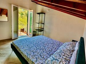 a bedroom with a bed and a sliding glass door at Agriturismo Yucca in Giustenice
