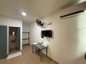 a room with a table and a tv on a wall at Hotel Empire Banting in Banting