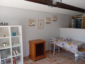 a room with a desk and a tv and a shelf at La maison multicolore in Salon-de-Provence