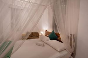 a bedroom with a canopy bed with white curtains at Vihanga Village - Jungle retreat in Dambulla in Dambulla